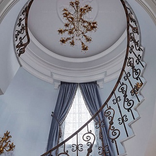 Винтовая мраморная лестница с коваными перилами